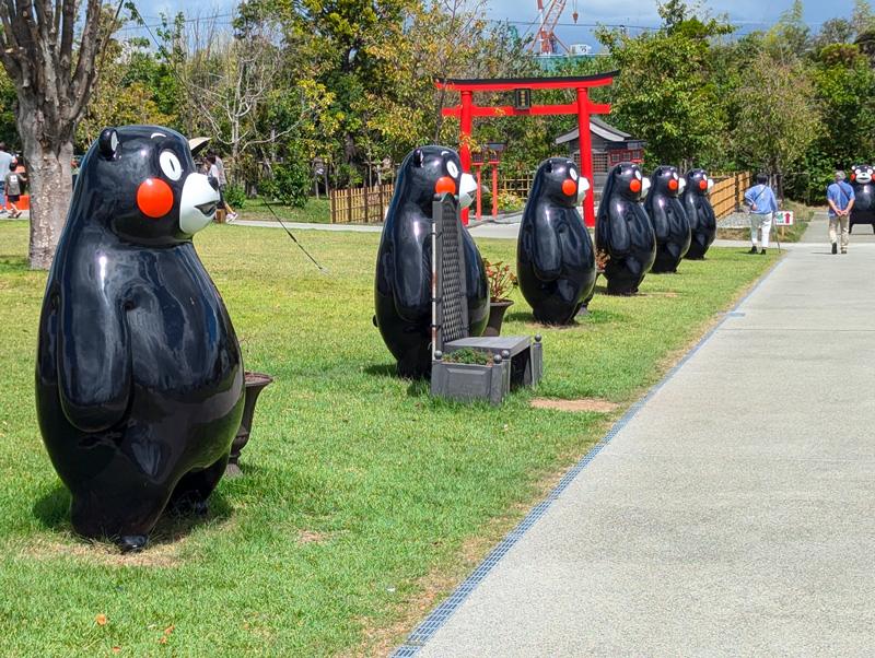 真っ赤な鳥居前で「いらっしゃい」と出迎えるくまモンたち